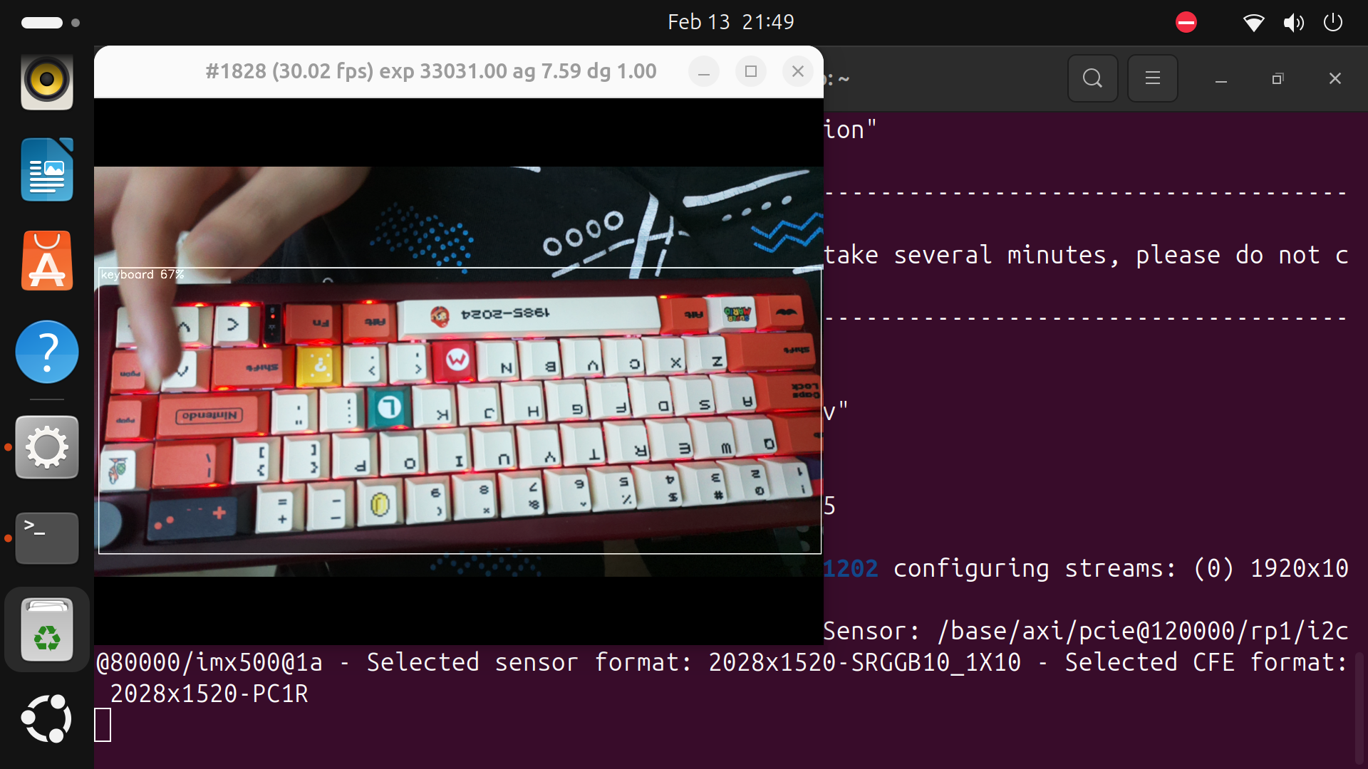 rpicam-hello MobileNet application window showing a preview of a keyboard with a person's hand over the cursor keys. Around the keyboard, an outline is drawn with the label "keyboard 67%" indicating the AI module has recognized this portion of the image as containing a keyboard.